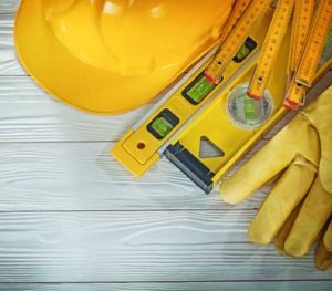 Photo of a hard hat, rulers, levels and gloves